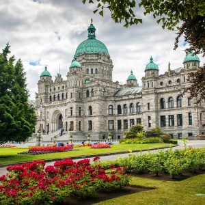 An old historic building in Victoria, BC with gardens in front.